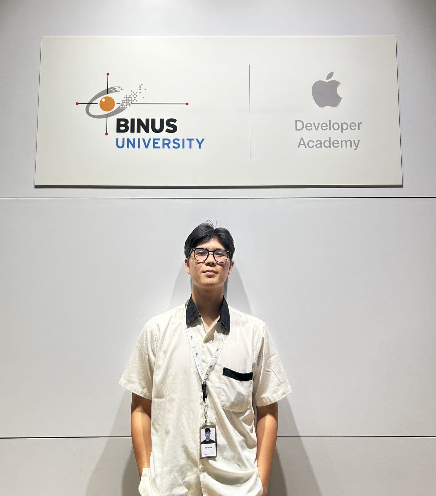 Kevin Bryan standing under the BINUS University and Apple Developer Academy sign